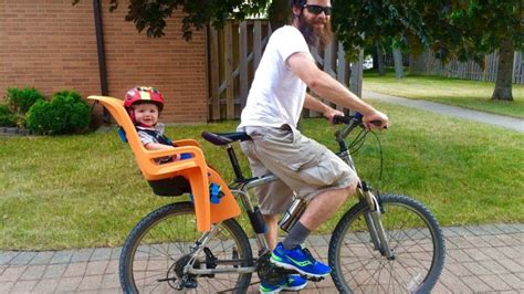 Infografía o esquema de la silla portabebé Kid Rider adaptada a bicicleta plegable o patinete eléctrico, mostrando su integración en el manillar y la posibilidad de plegado