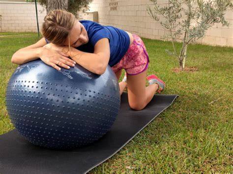 Mujer embarazada a cuatro patas con el tronco apoyado en fitball, activando core y suelo pélvico.