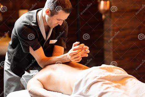 Foto de un padre haciendo un masaje abdominal suave a su bebé en el sentido de las agujas del reloj.