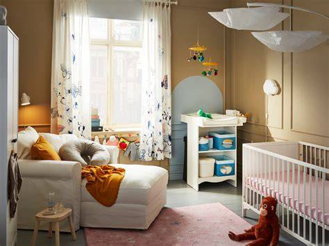 Habitación de bebé con un sillón de lactancia moderno, una mesita auxiliar y luz tenue.