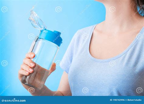 mujer bebiendo agua de una botella reutilizable