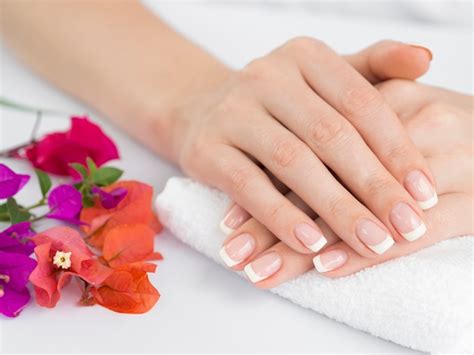 Manos de mujer embarazada con uñas cuidadas y pintadas