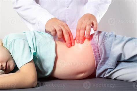 Bebé con abdomen distendido, con un padre dándole un masaje abdominal suave