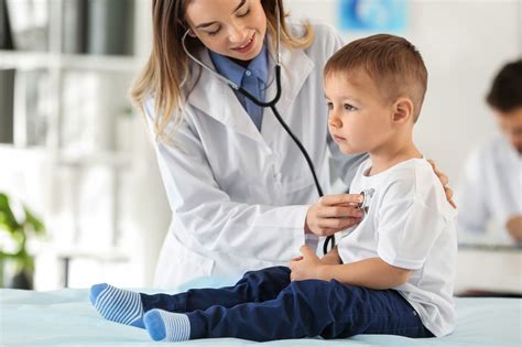 Equipo médico de cardiología pediátrica interactuando con un niño paciente y sus padres.