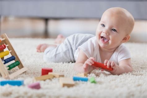 Bebé de 4 meses jugando boca abajo y levantando la cabeza
