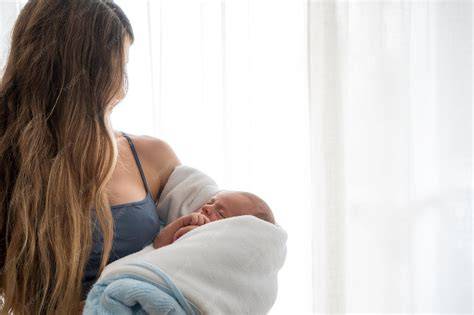 Bebé amamantando plácidamente en brazos de su madre durante la noche