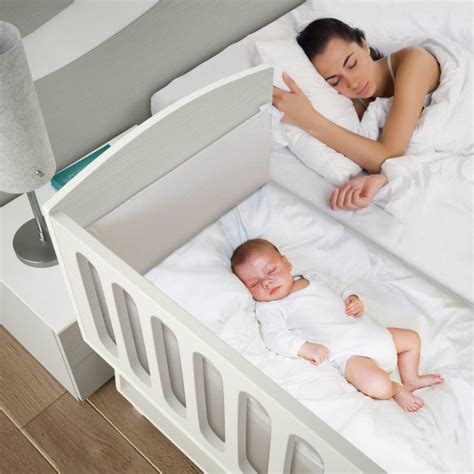 Madre durmiendo con su bebé en una cuna colecho