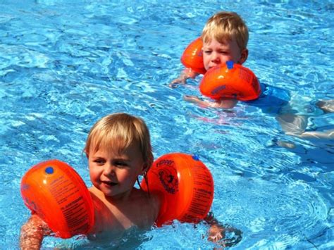 Niño usando manguitos en la piscina