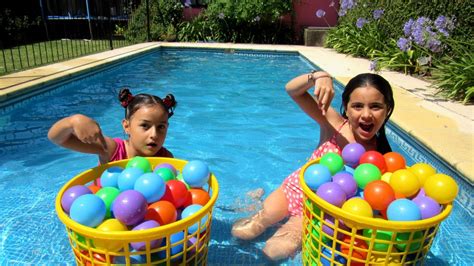 Niños jugando con anillas y pelotas en una piscina