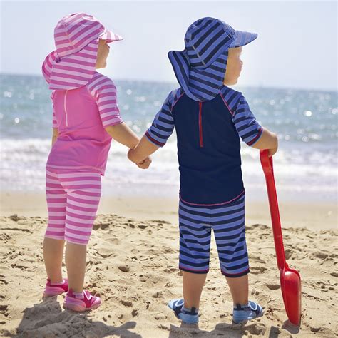 Niños con bañadores de protección solar y sombreros