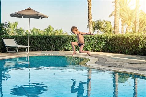 Niño mayor en la piscina usando un bañador pañal adaptado