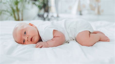 Bebé de 3 meses con los puños cerrados, durmiendo o en estado de alerta