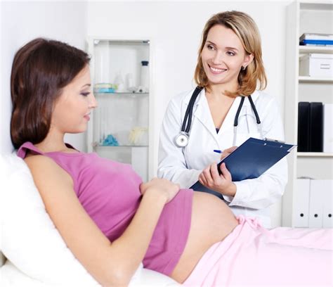Mujer embarazada sonriendo mientras consulta a su médico