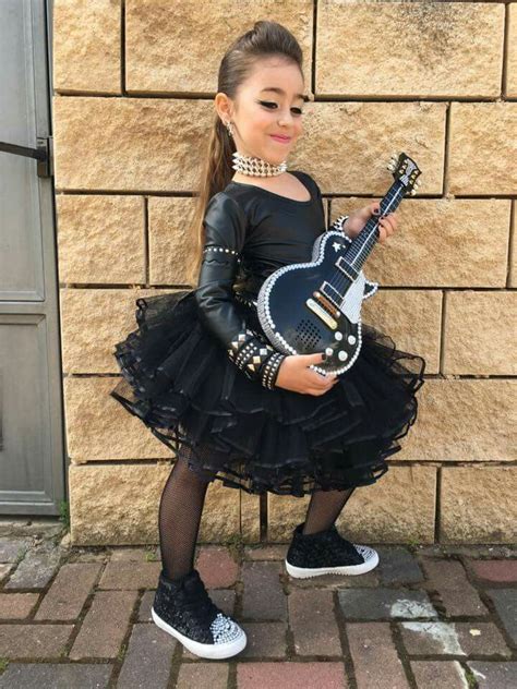 Foto de bebés y niños pequeños vestidos con atuendos rockeros, chaquetas de cuero de imitación y tutús