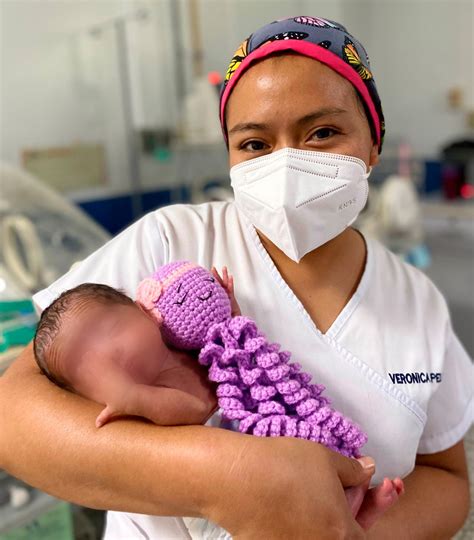Foto de voluntarios interactuando con niños o bebés prematuros en un entorno de apoyo