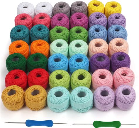 Foto de materiales para crochet: ovillos de lana de algodón de diferentes colores, ganchillo, marcapuntos