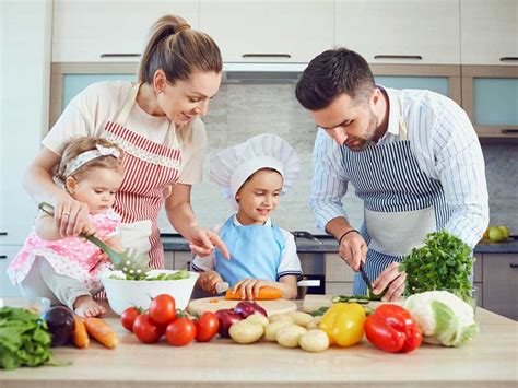 Niños cocinando con sus padres, manipulando alimentos y divirtiéndose en la cocina