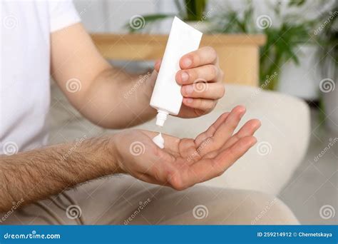 Primer plano de una mano aplicando crema protectora en la zona del pañal.