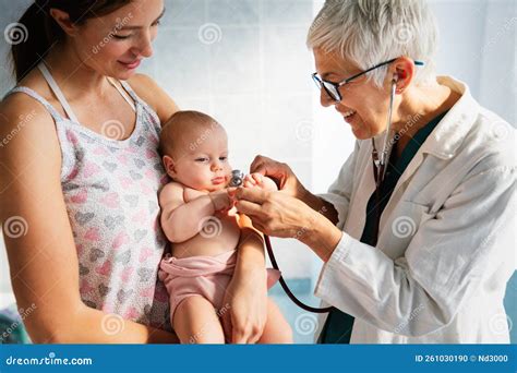 Pediatra examinando a un bebé mientras la madre observa