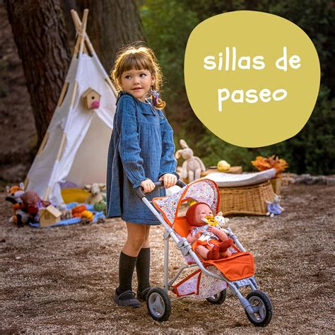 Niños jugando con sillas de paseo para muñecas en un parque.