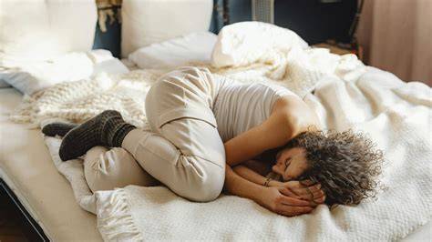Esquema de una persona durmiendo en posición fetal clásica con almohada entre las rodillas