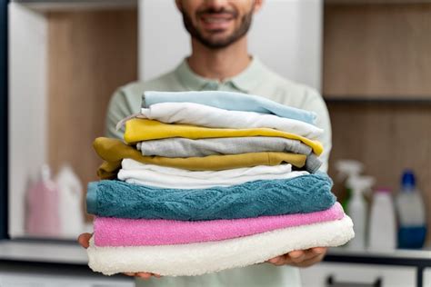 Manos de adulto doblando ropa de bebé limpia y suave