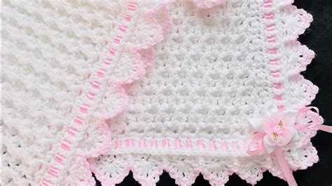 fotografía de alta calidad mostrando detalles de una manta de bebé tejida a crochet con texturas suaves