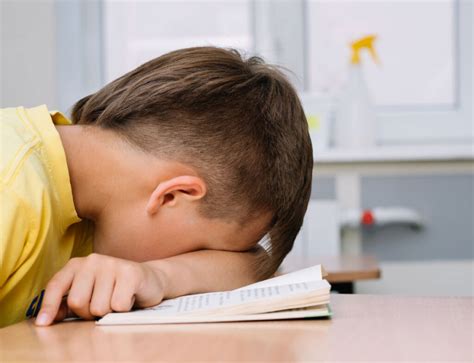 Ilustración de un niño somnoliento o con problemas de concentración en la escuela