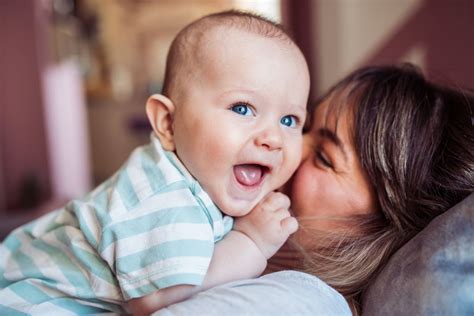 Una madre con su bebé, mostrando emociones mixtas de felicidad y agotamiento.