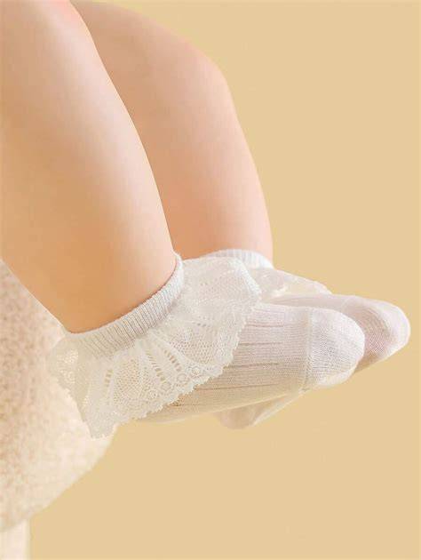 Calcetines de bebé blancos con delicado encaje, adecuados para un bautizo.