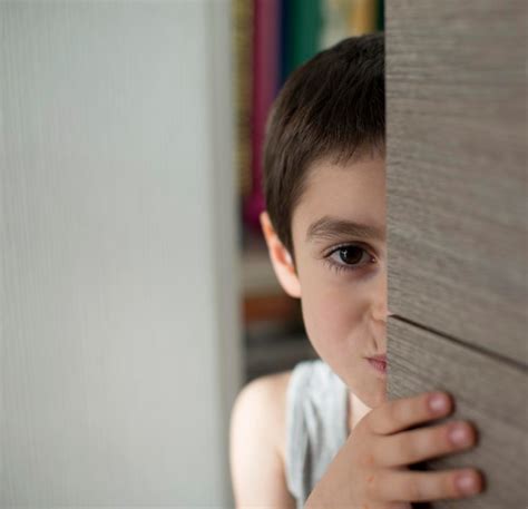 Niño escondiéndose detrás de su madre por miedo