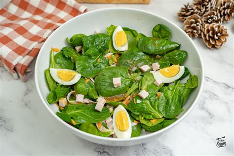 Plato principal de ensalada de espinacas frescas con queso feta desmenuzado y tomates cherry vibrantes, presentado de forma atractiva.