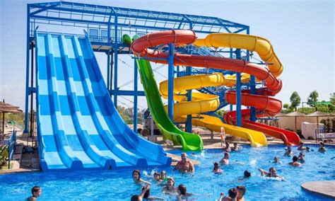 Niños jugando felices en una piscina con toboganes en un resort mexicano.