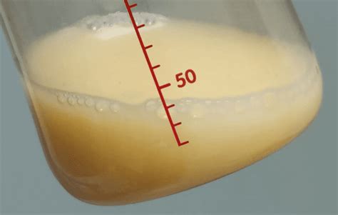 Foto de una gota de calostro dorado en un dedo