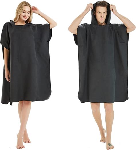 Persona cambiándose cómodamente en la playa usando un poncho cambiador de toalla