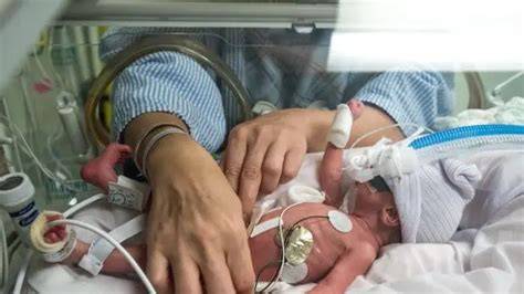 Una familia abrazando a su bebé prematuro en un entorno hospitalario suave