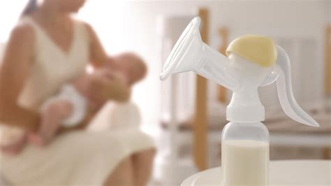 Madre trabajadora extrayéndose leche con sacaleches en la oficina
