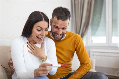 Ilustración de una pareja feliz mirando un test de embarazo positivo.