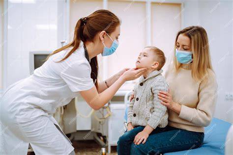 Foto de un niño sonriendo en el consultorio del pediatra con sus padres