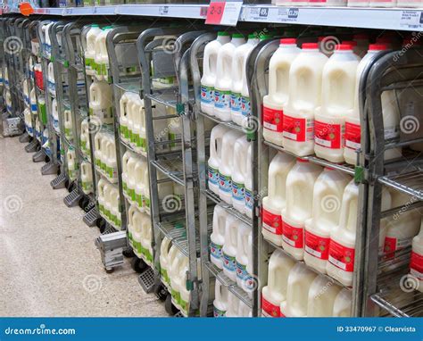 Botellas de leche fresca en un estante de supermercado