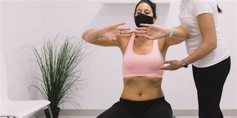Mujer realizando ejercicios hipopresivos con la ayuda de un fisioterapeuta.