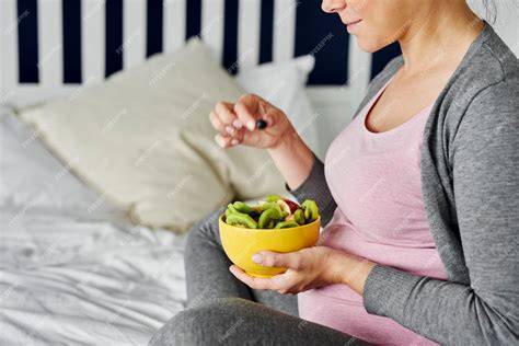 Mujer embarazada comiendo un snack saludable