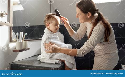 Padres peinando el cabello de su bebé con un cepillo suave
