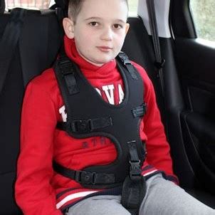 Foto de niño abrigado en silla de coche, con arnés aparentemente ajustado pero espacio visible