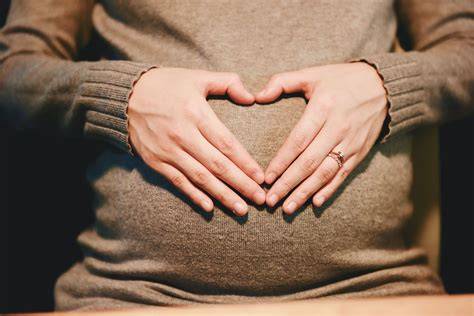 Foto de una mujer embarazada preparando un bolso de maternidad