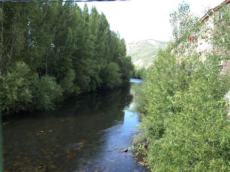 Vista panorámica del nacimiento del río Bernesga en el Puerto de Pajares, rodeado de montañas y vegetación de alta altitud.