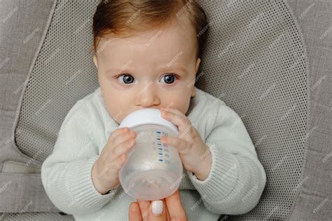 Bebé bebiendo un biberón de leche de fórmula