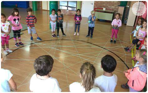 Niños en círculo pasando un ovillo de lana, creando una telaraña