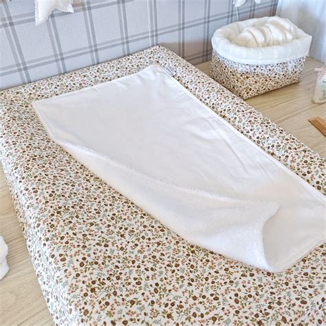 Montaje de accesorios para cambiador: funda de algodón, toalla impermeable y colchón.