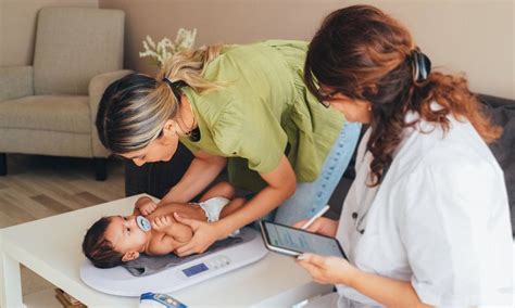 Matrona realizando una visita a domicilio a una madre y su bebé
